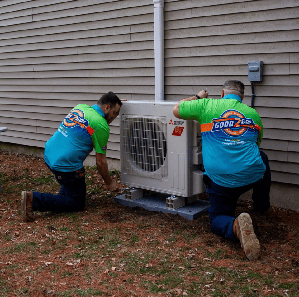 Good2Go heating and cooling technicians installing an outdoor Mitsubishi Electric HVAC unit at a home in Washington Township, NJ.
